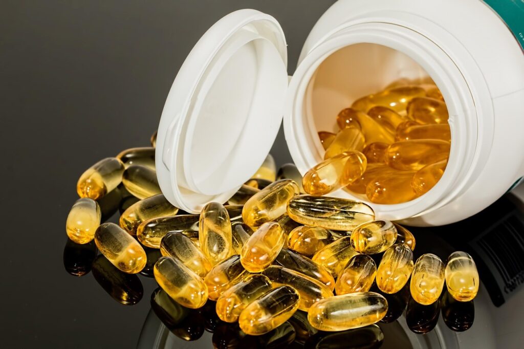 Capsules de complément alimentaire (oméga-3) renversées d'un flacon