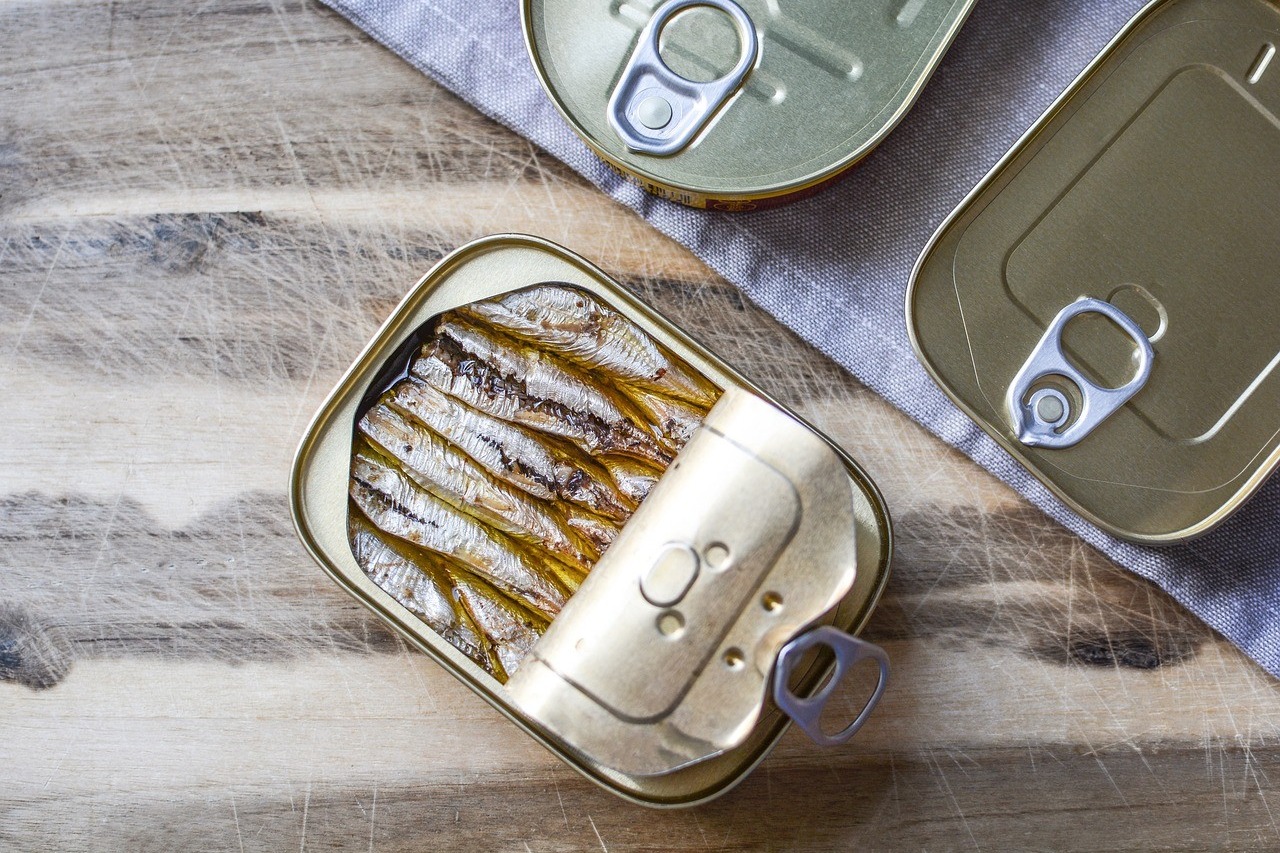 Boîte de sardines en conserve ouverte sur une table en bois