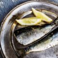 Sardines grillées sur une assiette avec quartiers de citron