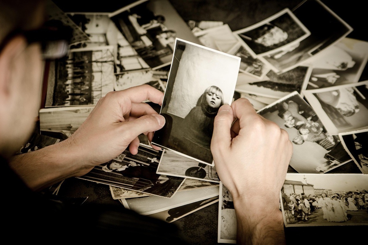 Mains tenant de vieilles photographies de famille, archives de plusieurs générations